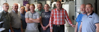 Gruppenbild mit zehn Männern in einer Werkstatt von der SHK-Schulung irische Delegation